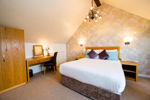 a hotel room with a bed and a desk and a bedroom at Raven Hall Hotel in Ravenscar