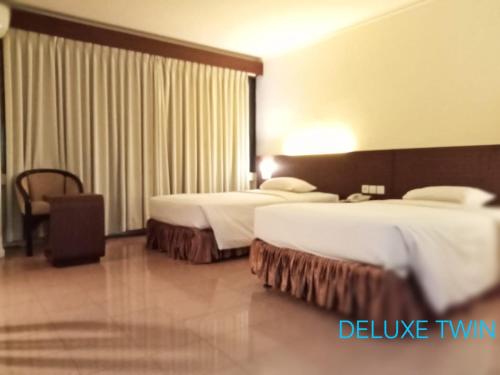 um quarto de hotel com duas camas e uma janela em A' Bahtera Residence em Klandasan Kecil