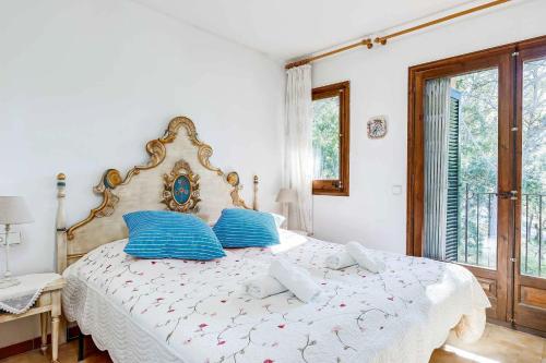 1 dormitorio con 1 cama grande con almohadas azules en La Torreta, en Palafrugell