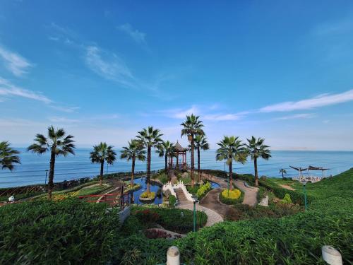 a view of a park with palm trees and the ocean at Habitacion baño Propio La Paz 1 in Lima