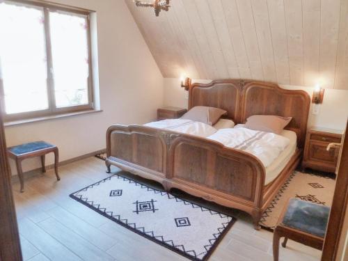 um quarto com uma grande cama de madeira num quarto em Appartement de 2 chambres avec jardin et wifi a Bernardville em Bernardvillé
