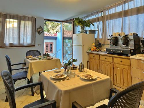 una cucina con 2 tavoli e un angolo cottura. di La Piazzetta a Giardini Naxos