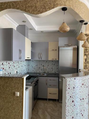 a kitchen with a stainless steel refrigerator and a sink at Art comfort in Rustavi