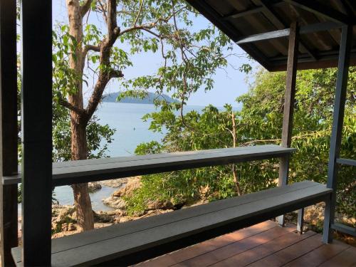 un banco en un porche con vistas al océano en The Big House, en Koh Chang