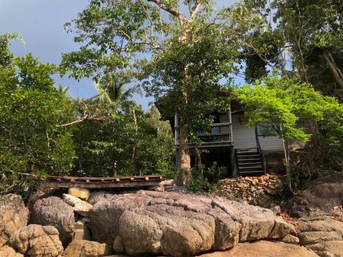 ein Haus auf einem Hügel mit Bäumen und Felsen in der Unterkunft The Big House in Koh Chang Ranong