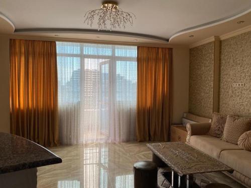 a living room with a couch and a large window at Art comfort in Rustavi