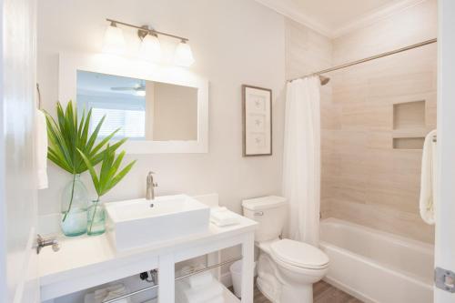 uma casa de banho branca com um lavatório e um WC em Isla Mirabelle - Waterfront Boutique Resort, Island Paradise, Prime Location em Islamorada