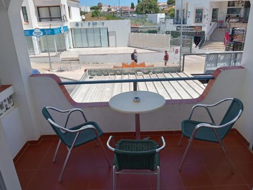 uma mesa e cadeiras num quarto com vista para a rua em "CASA RAMOS" Oura Nightlife Street Guest House em Albufeira