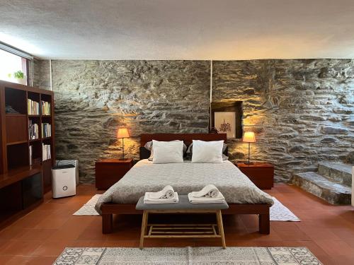 a bedroom with a bed and a stone wall at Quinta Da Estrada Winery Douro Valley in Peso da Régua