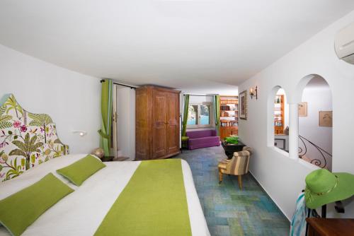 1 dormitorio con 1 cama con colcha verde y blanca en Villa Torre Trasita luxury suites, en Positano