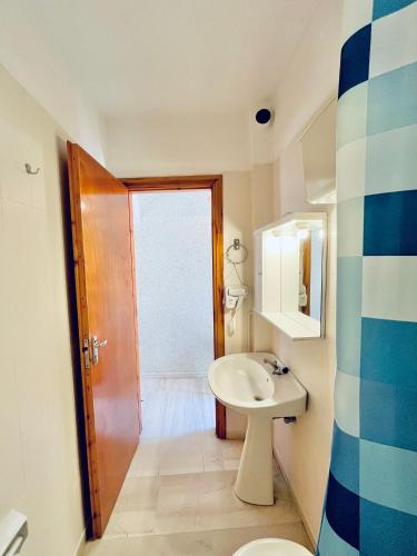 a bathroom with a sink and a toilet at Oelia Rooms & Apartments in Agia Marina Aegina