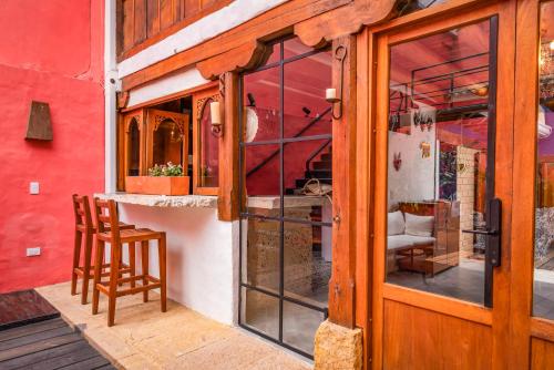 a building with a wooden door and a chair outside at Hotel Caney Villa de Leyva in Villa de Leyva
