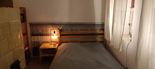 Dormitorio pequeño con cama y lámpara en Mókusles Vendégház, en Háromhuta