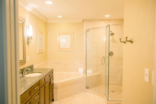 a bathroom with a shower and a tub and a sink at Harborwalk Village Two Bedroom Vacation Rental in Destin