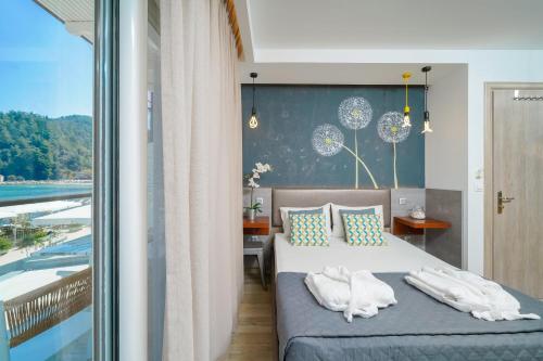 a bedroom with a bed with towels on it at Ester Luxury Rooms in Skala Potamias