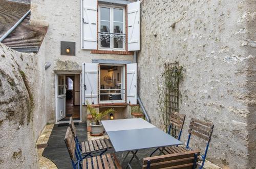 - une table et des chaises sur la terrasse d'un immeuble dans l'établissement L'Octroi, maison au cœur de St Dyé sur Loire, à Saint-Dyé-sur-Loire