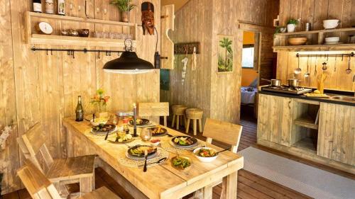 a kitchen with a wooden table with food on it at Naturéo in Seignosse