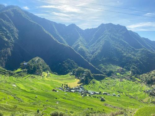 een groene vallei met bergen op de achtergrond bij Batad Pension and Restaurant in Banaue