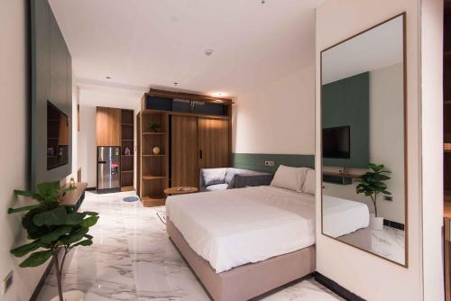 a bedroom with a white bed and a mirror at Luxe Paradise Suites Hotel Hoang Cau in Hanoi