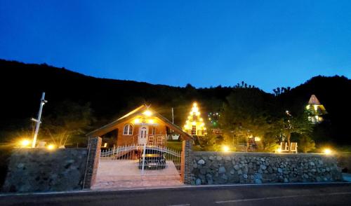 Una casa de noche con luces encendidas. en Vilat Pllumaj, en Gropat e Selcës