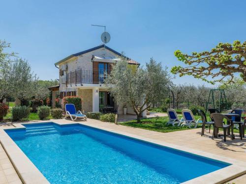 a villa with a swimming pool in front of a house at Villa Marinko in Umag
