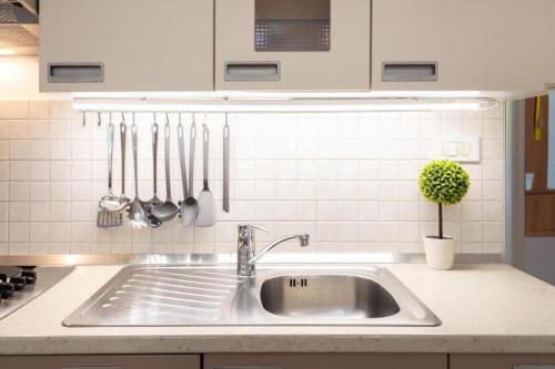 a kitchen counter with a sink and utensils at Kennedy Apartment URBAN STAY in Zagreb