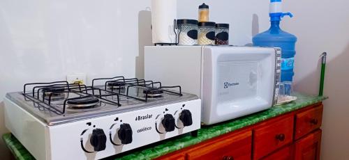 a stove and a microwave on top of a counter at Flat JM in Parauapebas