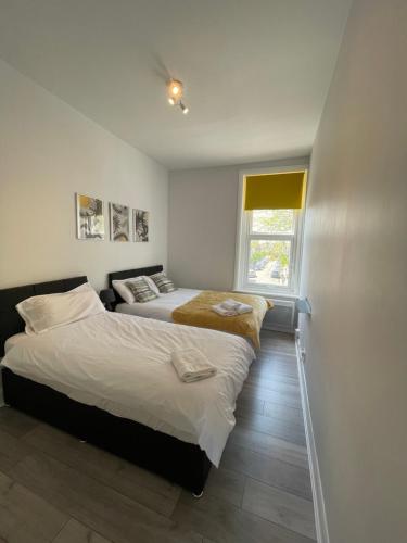 a bedroom with two beds and a window at Chamberlayne Inn in London