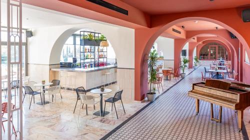 ダシアにあるIolida Corfu Resort & Spa by Smile Hotelsのピアノ、テーブル、椅子が備わるレストラン