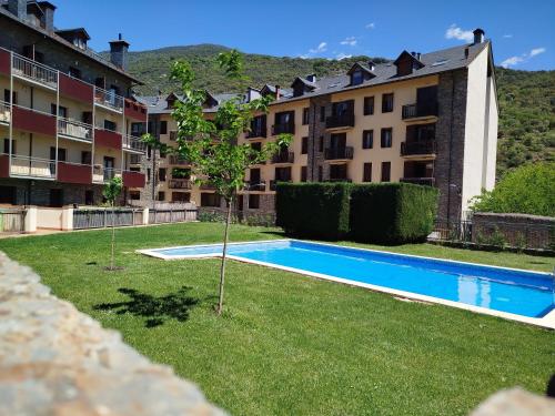 a swimming pool in the yard of a apartment building at Apartaments Sort Pirineus in Sort