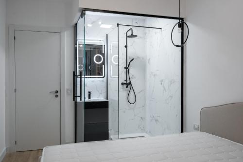 ein Bad mit Dusche und ein Bett in einem Zimmer in der Unterkunft Golden Grove I 1 BR apartment near Romexpo in Bukarest