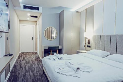 ein Schlafzimmer mit einem großen weißen Bett und einem Spiegel in der Unterkunft ONKA OTELCİLİK TURİZM TİCARET LİMİTED ŞİRKETi in Istanbul