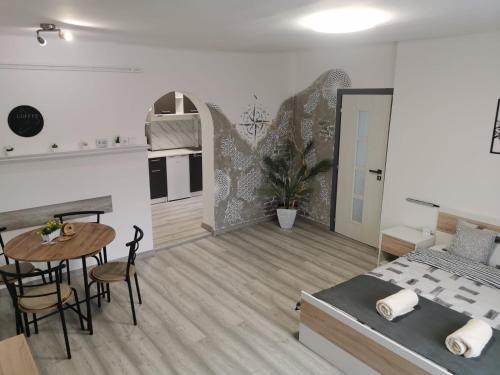 Un dormitorio con una cama y una mesa y una cocina. en Kucko Vendeghaz Guesthouse, en Sárospatak