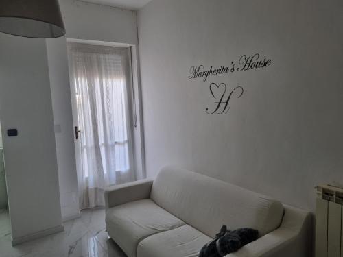 a living room with a couch and a sign on the wall at Margherita's House in Turin
