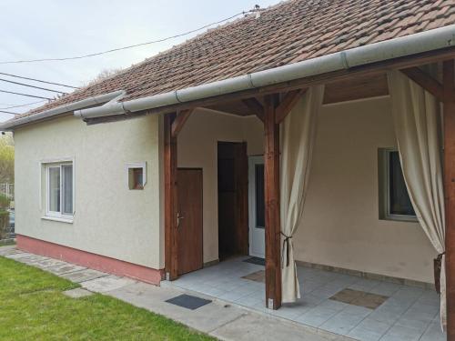 Kucko Vendeghaz Guesthouse في ساروسباتاك: منزل به شرفة مغطاة مع باب