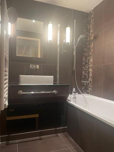 une salle de bain avec une douche, un lavabo et une baignoire dans l'établissement Sydney, à Juvignac