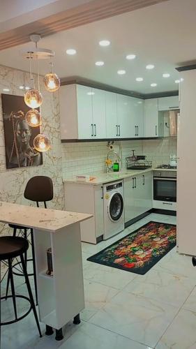 a kitchen with white cabinets and a rug on the floor at Kiralık daire in Yalova