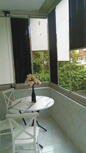 a white table and chairs in a room with windows at Kiralık daire in Yalova