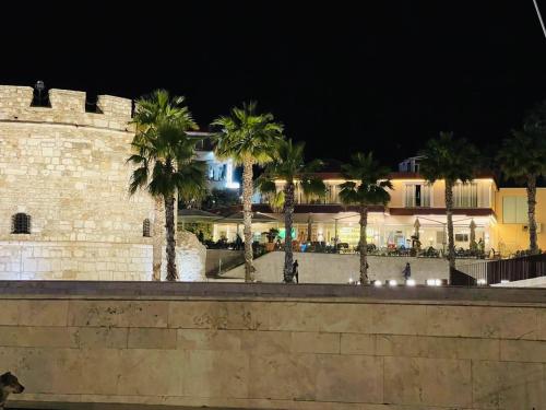 a wall with palm trees in front of a building at Bizant Boutique Hotel & Coffee,Bar in Durrës