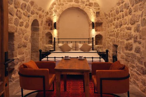 1 dormitorio con 1 cama, mesa y sillas en Zabel Hotel, en Mardin