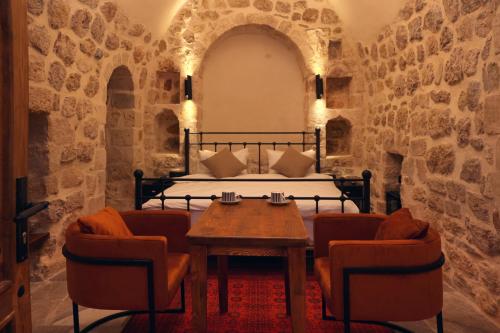 a bedroom with a bed and a table and chairs at Zabel Hotel in Mardin