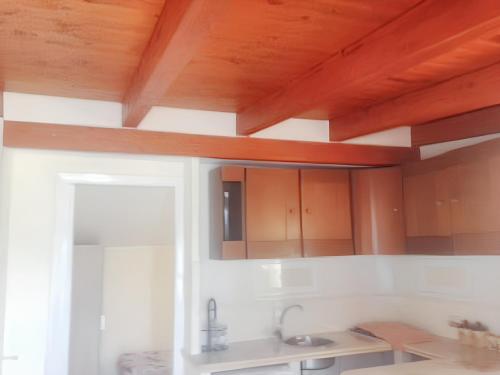a kitchen with wooden ceilings and wooden cabinets at 2 bedrooms apartement with shared pool enclosed garden and wifi at Crispiano in Crispiano