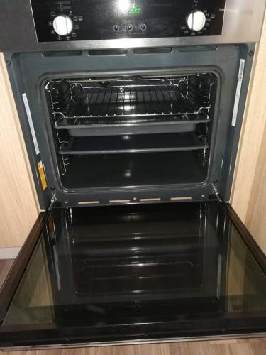 an oven with its door open in a kitchen at Tiny House Wemding in Wemding