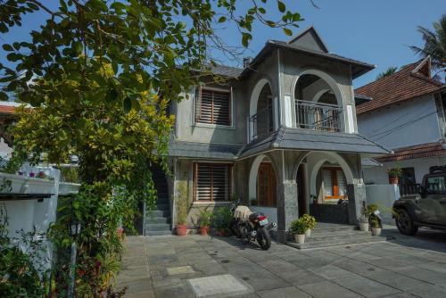 a house with a motorcycle parked in front of it at Mickey Homestay in Thekkady