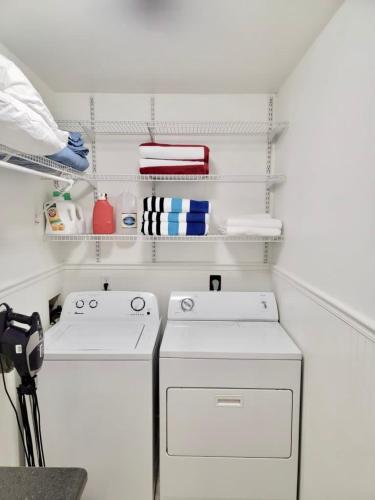 a kitchen with two white appliances and white shelves at This Charming 2 bed condo is next to downtown Saugatuck and includes a pool! in Saugatuck