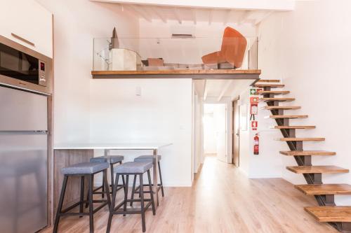 a living room with a staircase and stools at Apartamento Porta14 3 in Chaves