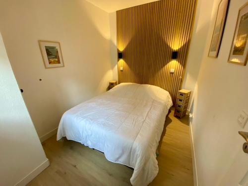une chambre avec un lit blanc dans une pièce dans l'établissement Magnifique et cosy appartement avec piscine et golf, à Lacanau-Océan