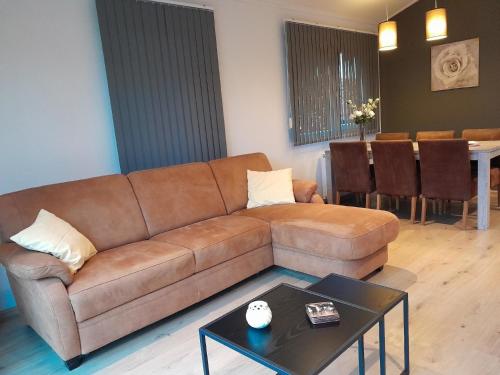 sala de estar con sofá marrón y mesa en Ferienchalet an der Grenze zwischen Brabant und Zeeland, en De Heen