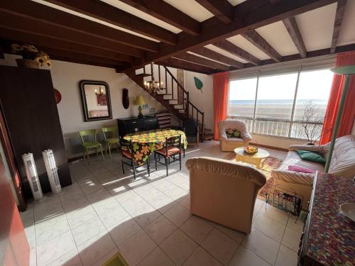 un salon avec un canapé, une table et des chaises dans l'établissement Duplex T4 en front de mer, à Saint Pierre La Mer