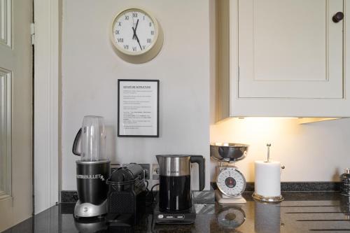 a kitchen counter with a blender and a clock on the wall at Berkeley House near Bath in Bath